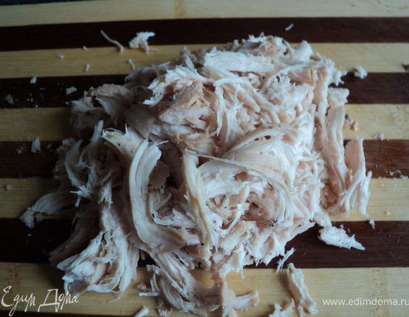 Запеченную куриную грудку порезать поперек на куски длиной 3см и порезать брусочками или разобрать на волокна.