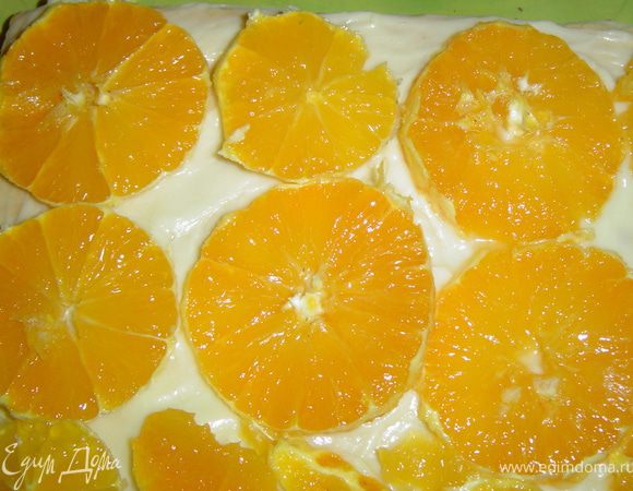 А на следующий корж - нарезанные на кружки апельсины.