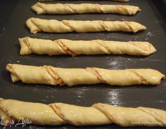 Выложить на противень, смазанный сливочным маслом. Желток смешать с 1 ст.л. молока или воды и обмазать завитки. Поставить в разогретую до 200°С.