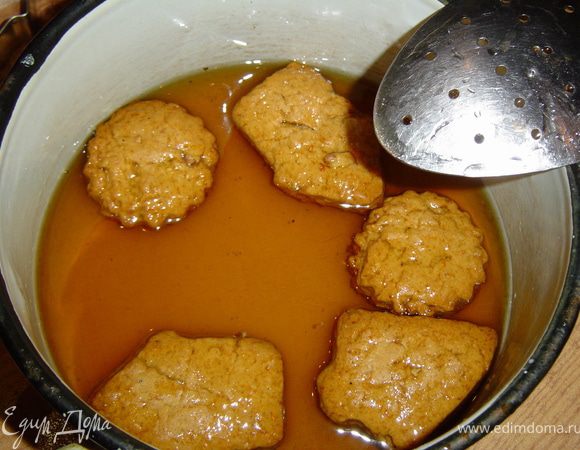 Пока запекается печенье, готовим сироп. Для этого в кипящей воде растворяем сахар и кипятим его 3-5 минут. Снимаем с огня, добавляем мед, хорошо перемешиваем и даем остыть. Горячее печенье опускаем на 1 минуту в сироп,