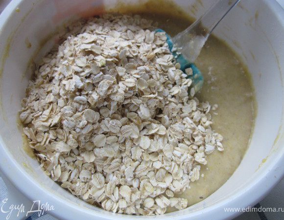 Всыпаем овсяные хлопья и лопаточкой замешиваем мягкое и однородное тесто.