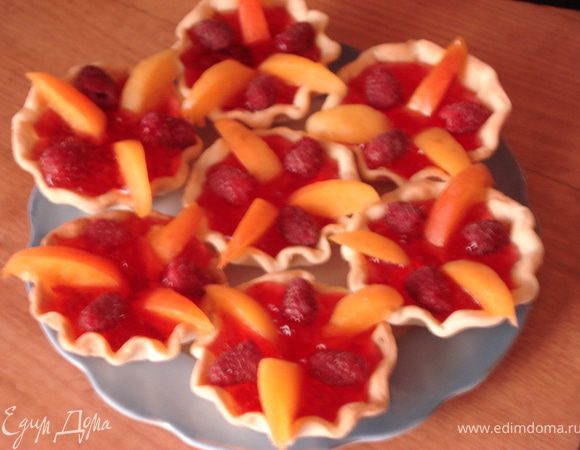 Абрикосы нарежьте дольками. Уложите абрикосы в корзинки, между ними поместите малину.