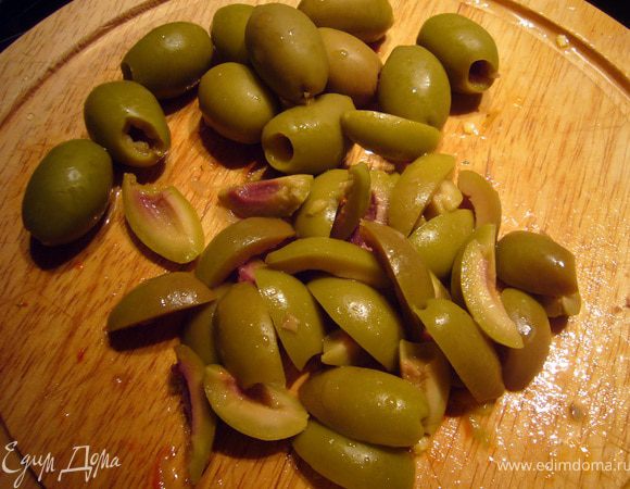Лук порезать тонкими полукольцами. Оливки порезать вдоль на 4 части.