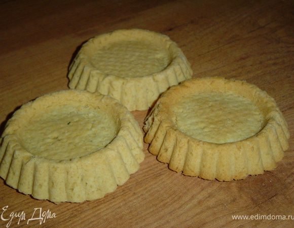 Готовим тарталетки, для этого масло порубить с мукой, хорошо перемешать и посолить по вкусу, добавить желтки, сметану и быстро замесить тесто. Поставить тесто на 10 минут в холодильник, а затем раскатать в тонкий пласт, вырезать стаканом кружки и выложить в смазанные жиром формочки, чтобы тесто покрывало дно и бока формочки. Выпекать 20-25 минут при температуре 180°С.