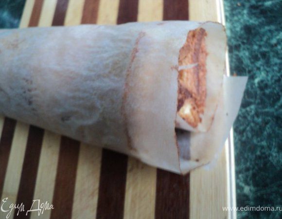 Бисквиты слегка охладить и свернуть вместе с бумагой в рулетики.