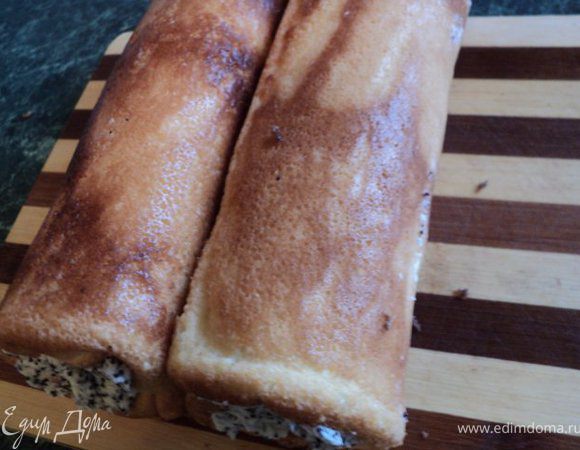 Рулетики из белого бисквита аккуратно развернуть, освободить от бумаги, смазать кремом и снова свернуть рулетом.