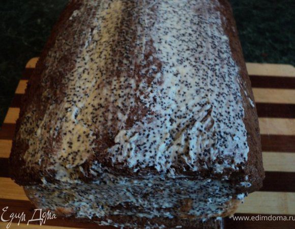 Смазать кремом оставшийся пласт шоколадного бисквита и выложить его кремом вниз поверх рулетиков, слегка прижав по краям, сформировав головку совы. Сверху смазать оставшимся кремом и поставить пляцок в холодильник на 1 час.