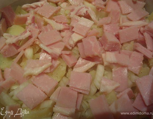 Форму застелить бумагой либо смазать маслом. Выложить слой картофеля, посолить и поперчить. Добавить лук и бекон (1/2), сверху сыр (1/2, смешав 2 вида сыра). 