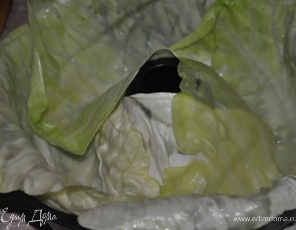 С капусты снять верхние листья, вырезать кочерыжку и отварить до мягкости.
Снять листья, отрезать уплотнения и выстелить ими дно и стенки круглой формы для запекания.
Оставшуюся капусту мелко нашинковать.