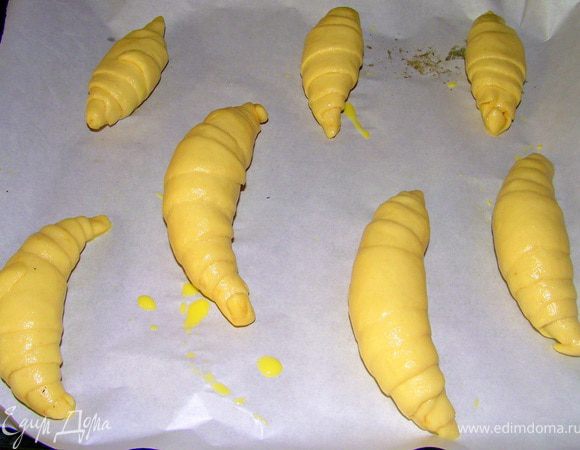 Получившийся круассан обмакнуть в желтковую смесь и выложить на противень застелённый пергаментом, дать отдохнуть на противени 10 минут.