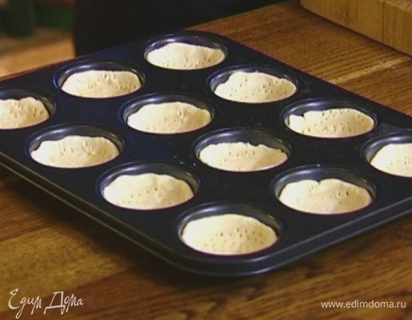 Стаканом вырезать из теста кружки и выложить в формы для кексов, равномерно распределяя по стенкам, затем часто наколоть вилкой.