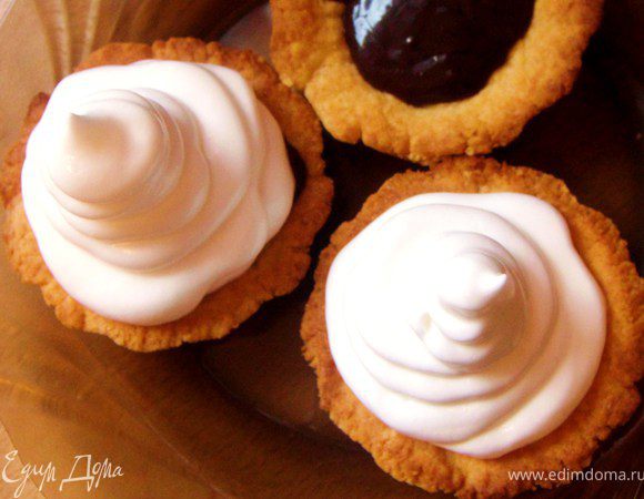 Выложите белковый крем в кулинарный мешочек или шприц и выдавите на корзиночки.