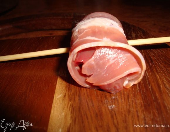 Аккуратно заворачиваем кусочек печенки в пластинку бекона и насаживаем на шпажку.