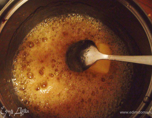 В сотейнике смешать воду и сахар, поставьте на плиту и cварить золотистый сироп. Добавьте в него масло и убавьте нагрев, готовьте 1 минуту.

