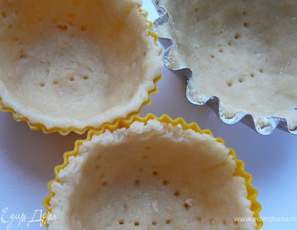 Выложить в каждую формочку тесто.Придавить его к стенкам и дну формочек,придать ему форму корзинки,сделать бортики.Наколоть тесто вилкой.