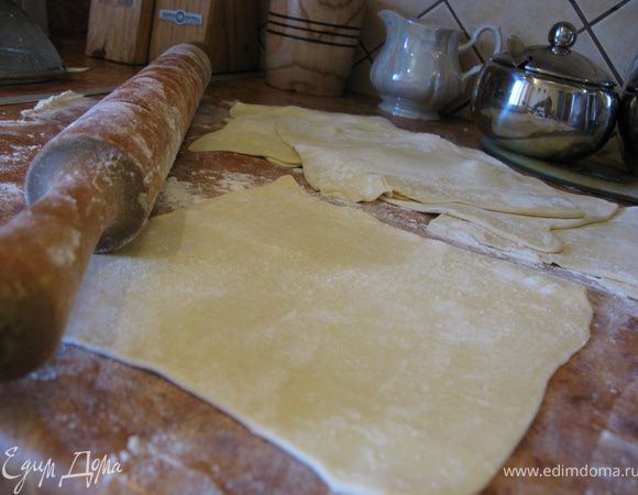 Тесто разрезать на 8 одинаковых частей и немного раскатать их на посыпанном мукой столе.