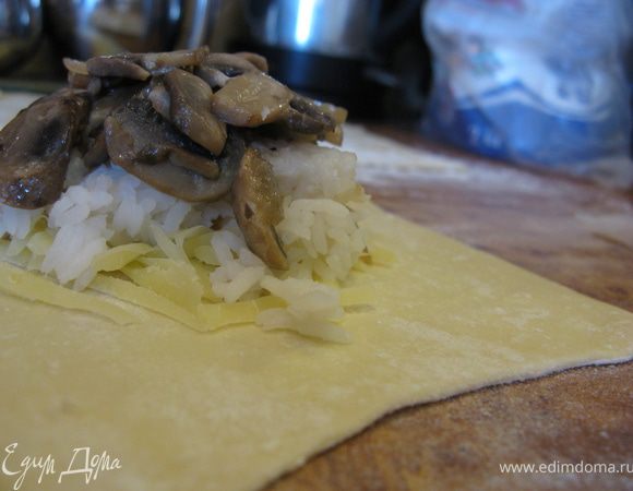 На каждую лепешку выложить порцию тертого сыра, на него - вареный рис, затем кусочек обжаренной рыбы и сверху грибы.