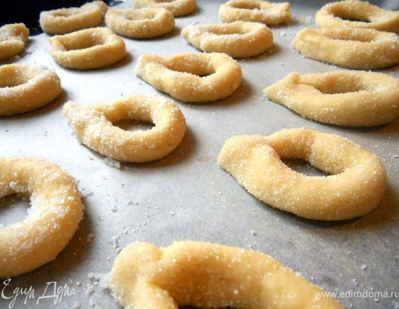 Скрепить концы, чтобы получились овальные крендельки. Выложить на противень, застеленный бумагой и выпекать в предварительно разогретой до 180+- С. духовке, до легкого золотистого оттенка. Если обваляли в сахаре с двух сторон, лучше в процессе перевернуть, чтобы низ не подгорел. ***Весьма душевно, я бы порекомендовал к сахару добавить немного корицы, или в тесто - апельсиновую цедру. Хотя и без добавок простое и вкусное печенье:)***