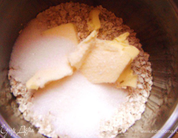 Смешать размягченное масло с сахаром, разрыхлителем и овсяными хлопьями. Тщательно перемешать (тесто получается рассыпчатым, как крошка). Выложить половину на дно разъемной формы 20 - 24 см диаметр.
