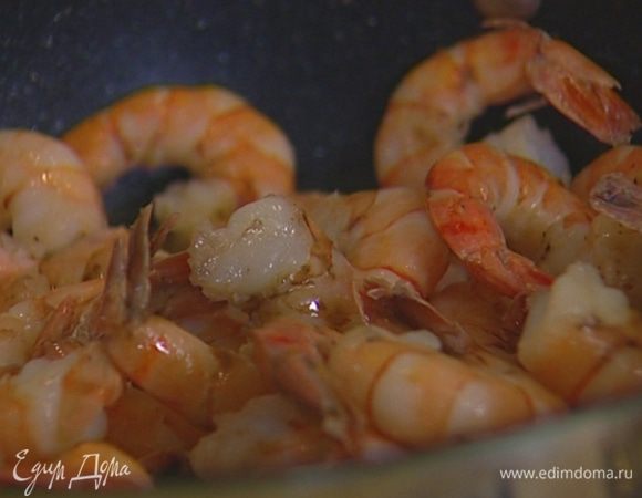 Разогреть в сковороде оливковое масло, выложить креветки и обжаривать практически до готовности, затем влить вино, перемешать и дать алкоголю выпариться.