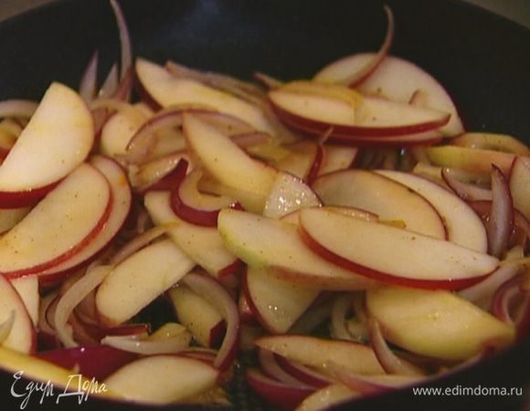 В сковороду с маслом, где обжаривался бекон, выложить яблоко и лук, посолить, поперчить и, помешивая, обжаривать 7−8 минут, пока лук не станет золотистым.