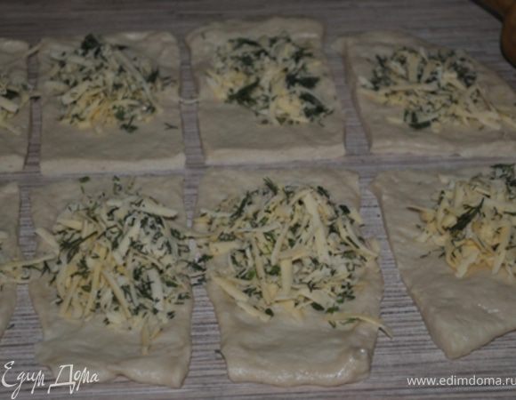 Готовое тесто разделить на 2 части. Раскатать в тонкий пласт, каждый разрезать на 10 прямоугольников.
Смазать маслом, в центр каждого положить начинку.