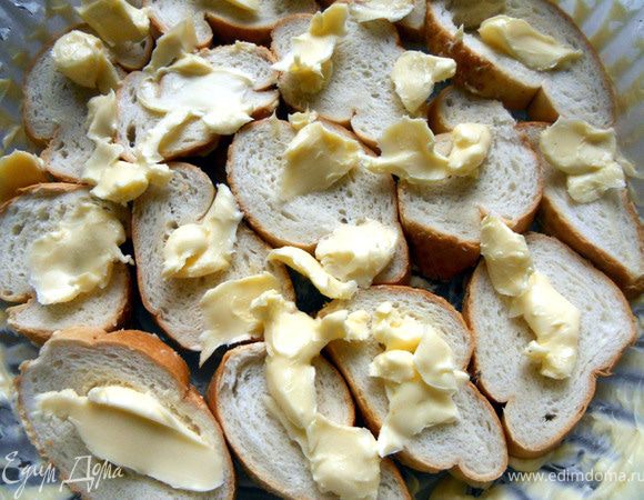 Жаропрочную форму обильно смазать сливочным маслом, выложить ломтики хлеба, каждый кусок также промазывая маслом (если это сдобная выпечка, количество можно уменьшить).  