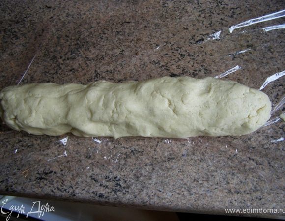Муку смешать с крахмалом, разрыхлителем и солью, смешать с масляно-яичной смесью. Скатать в колбаску, завернуть в пленку, убрать в морозильную камеру на 15 минут. 