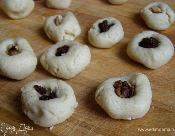 В каждый шарик вкатать по кусочку грецкого ореха или по нескольку изюминок