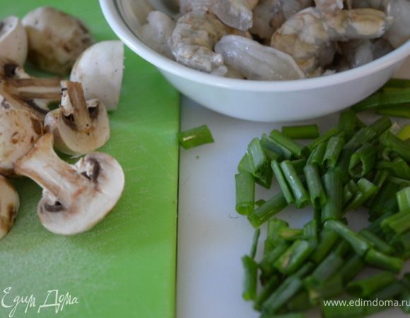 Вскипятить воду в большой кастрюле,сварить спагетти. Очистить креветки,нарезать шампиньоны ломтиками. Крупно нарубить зелен.лук.
