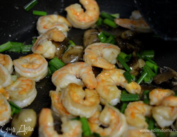 В сковороде нагреть 2 стол.л раст.масла. Добавить грибы и чеснок, обжаривать минут 5.
Влить оставшуюся 1 ст.л раст.масла, положить креветкии жарить 2 мин. Добавить зелен.лук и жарить еще пока креветки не станут розовыми и непрозрачными.

