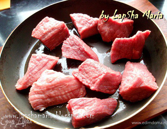 На разогретую сковороду налить немного оливкового масла и выложить куски говядины  по возможности свободно, так, чтобы они не соприкасались. Это делается для того, чтобы они обжарились и при этом не начали тушиться и не дали сок.