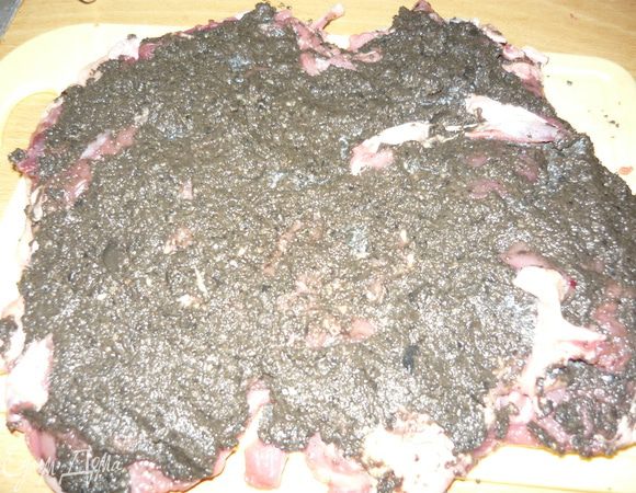 Вообще я планировала положить начинку как бы на место кости, но на практике оказалось, что гораздо удобнее будет заворачивать в противоположном направлении.
Намазать получившийся пласт мяса смесь измельченных маслин и чеснока, посолить, поперчить, свернуть и замотать ниткой.
