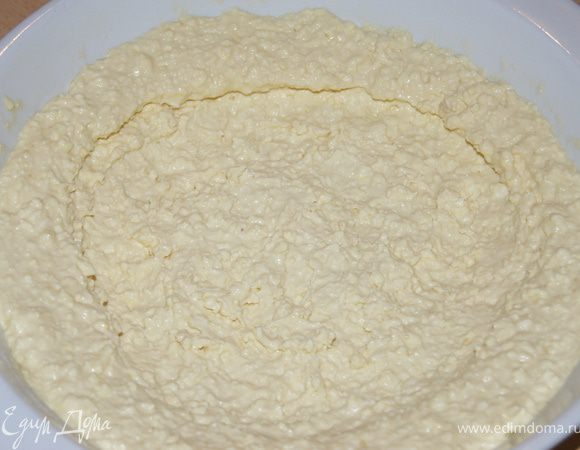 Духовку разогреть до 180С. Форму смазать растительным маслом и посыпать мукой. Взять 2/3 часть творожной массы выложить на низ формы и сделать бортики, насколько это возможно, так как творог будет немного уплывать вниз.