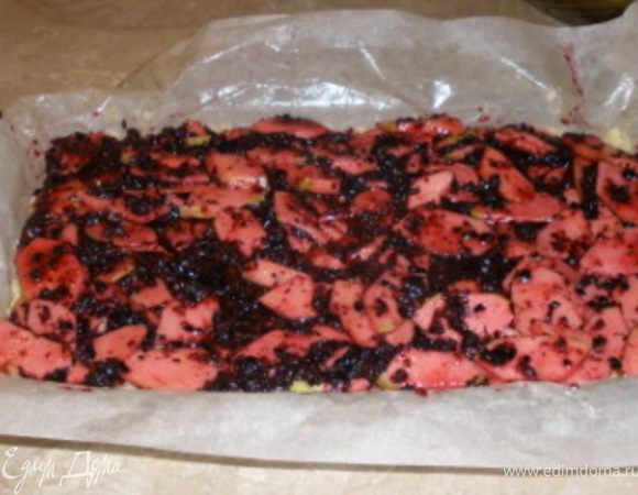 Бумагу для выпечки смазать сливочным маслом или маргарином, поместить в сковороду. Высыпать 2/3 части теста крошки и слегка примять.Сверху выложить начинку.