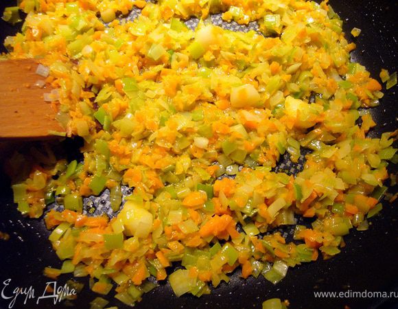 Половину сливочного масла (60 г) растопим на тихом огне, добавим белый лук и порей, будем пассеровать его на среднем огне минут 7, следя, чтобы лук стал прозрачным и мягким, но не менял цвет на золотистый. Добавим морковь и раздавленный ребром ножа зубчик чеснока, немного посолим, продолжим тушить овощи ещё минут 5-7. В конце приготовления чеснок уберём. 