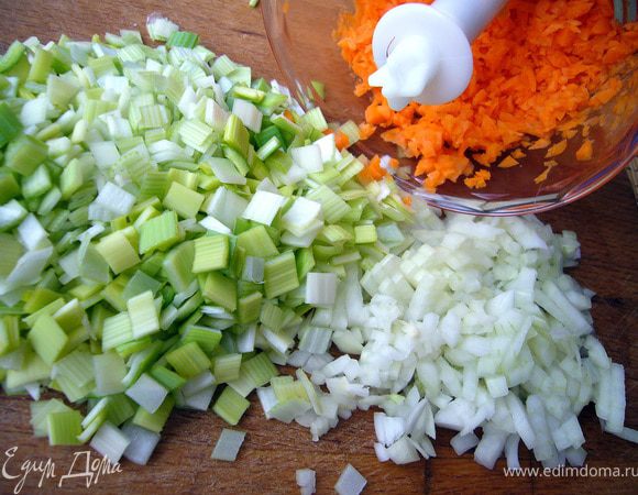 Приступим к приготовлению базы для ризотто (она же овощная база для супов) - соффритто. 
Помимо репчатого лука (который может быть и единственным в базе), я взяла лук-порей, который замечательно сочетается с грибами,  морковь для более яркого вкуса и цвета и зубчик чеснока для аромата.
Белый лук очень мелко нарежем. Стебель порея разберём, промоем от песка, обсушим и порежем также мелко. Морковь я измельчила в бленднре почти в крошку, но не совсем в труху:).