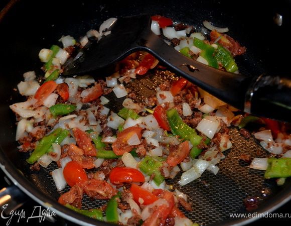 Картофель промыть,положить на противень,проткнуть вилкой местами,смазать или сбрызнуть маслом(спреем), в течение часа в духовке выпекать при тем-ре 200гр. В это время обжарить порезанный на мелкие брусочки бекон,добавить мелко порезанный лук,перец и помидор. 
