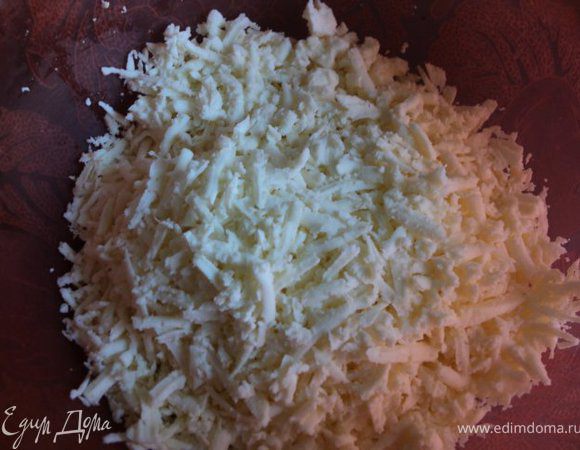Брынзу натереть на крупной терке. Яйцо взбить со сметаной.