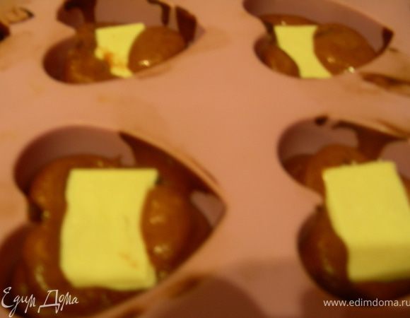 Затем кладем в каждый по кусочку батончика Марс или кусочку белого шоколада.