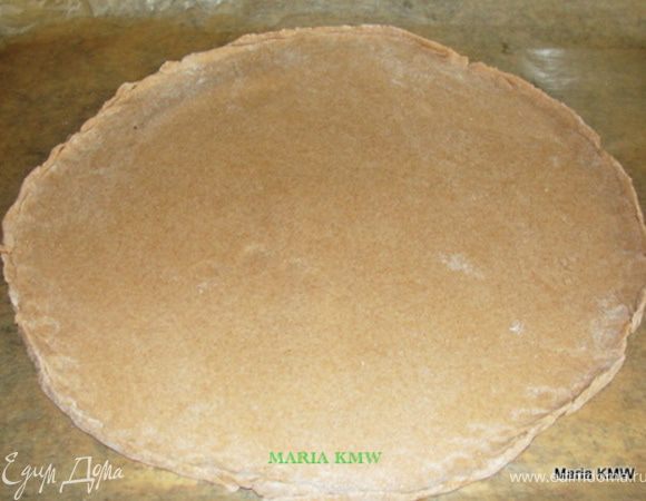 На противень выкладываем бумагу для выпечки. Тесто делим на две части. Тонко раскатываем, укладываем на противень. 