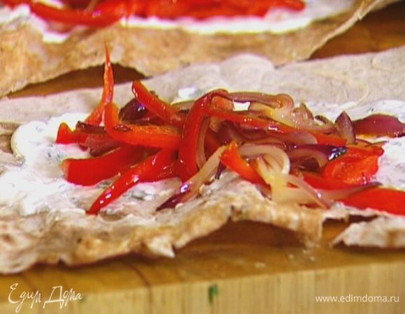 Половинки лаваша смазать сметанным соусом, выложить на каждую перец с луком и яйцо, свернуть в рулет.