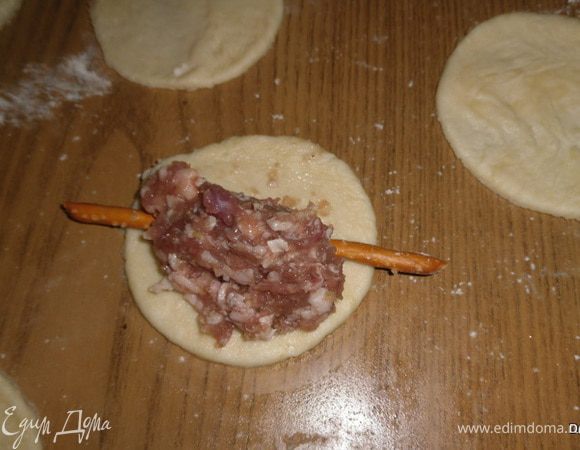 На каждый кружочек по центру положить соломку, чтобы края выходили за пределы кружочка. На каждый кружок с соломкой положить фарш, 