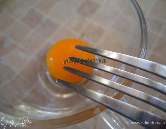 Взбить вилкой желток. Ввести его в смесь помешивая, еще немного прогреть (градусов до 60, до дымка). 