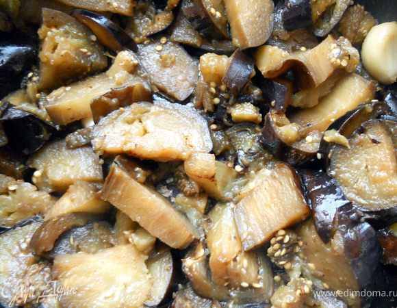 Огонь уменьшить, добавить чеснок (не измельчая), 1 ст.л. оливкового/растительного масла и немного воды. Накрыть крышкой и готовить еще минут 5-7, до мягкости. ***Вы можете выбрать иной способ обработки при котором баклажаны не впитывают много масла***. Чеснок удалить или оставить - чувствоваться вдальнейшем практически не будет, лишь легкий аромат придаст. Остудить. 