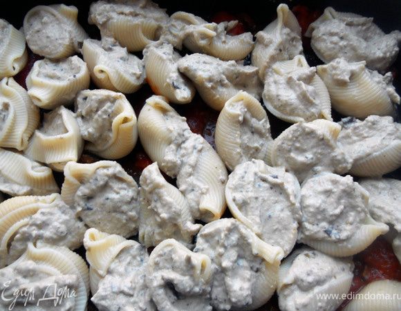 Пасту (у меня совсем мелкие ракушки, около 40 штук) отварить практически до готовности, немного остудить. Жаропрочную форму смазать тонким слоем томатного соуса. Начинить ракушки баклажанным муссом и выложить в форму. 
