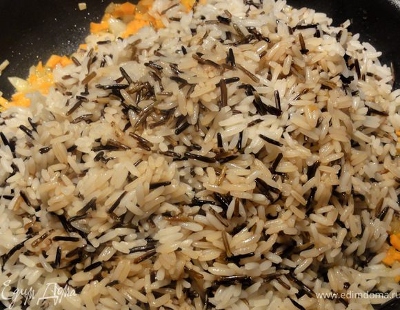 Добавить к овощам рис и перемешать, что бы овощи равномерно распределились. Влить соус и добавить обжаренный кунжут. Прогреть смесь помешивая, минут пять.