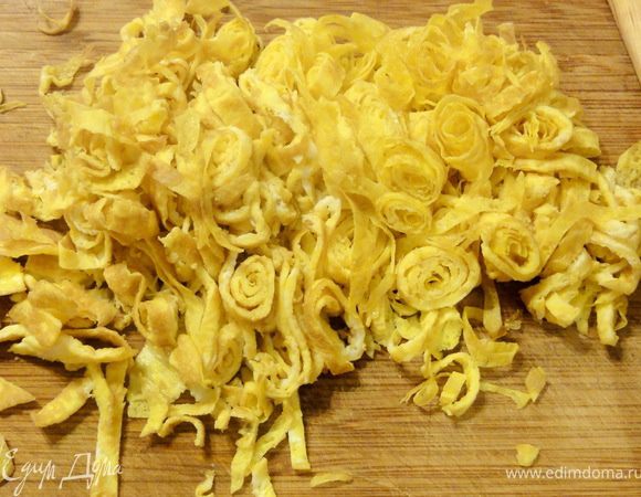 Каждый блинчик, пока он горячий свернуть в рулет и дать немного остыть. Затем нарезать тонкой соломкой.