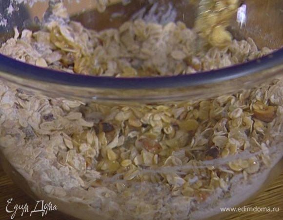 Соединить овсяные хлопья, муку, разрыхлитель, соду, соль, сахар, мед, орехи и цукаты, влить растопленное масло и все вымешать.
