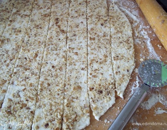 Раскатать тесто толщиной 0,5 см. Присыпать сахаром и орехами. Пройтись по коржу скалкой, чтобы орехи "утопить" в тесте. Затем нарезать кому как нравится, можно различными фигурными вырезками. 